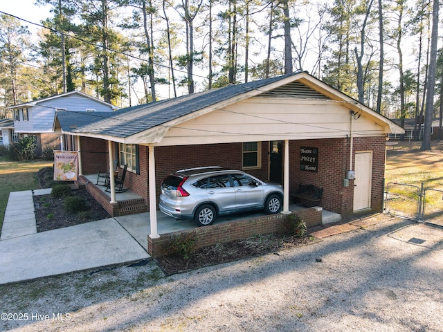 exterior space with fence, an attached carport, driveway, and a gate