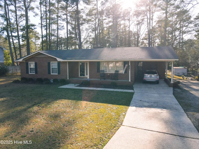 single story home featuring an attached carport, brick siding, driveway, and a front lawn