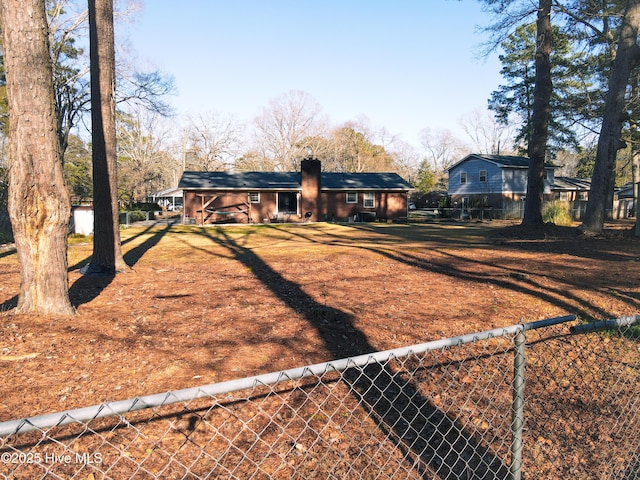 back of property with a fenced front yard and a carport