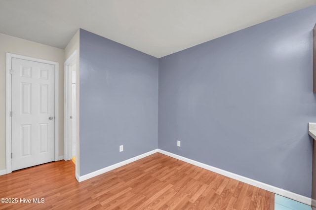 unfurnished room featuring light wood-style flooring and baseboards