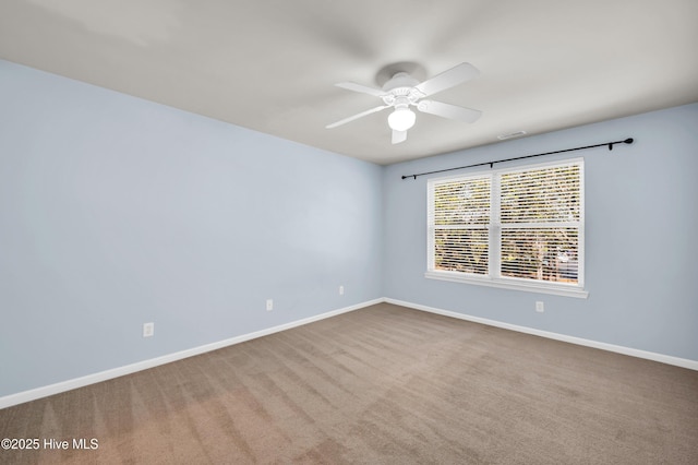 carpeted spare room with baseboards and a ceiling fan