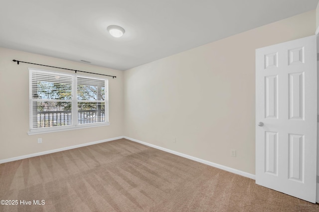 carpeted spare room featuring baseboards