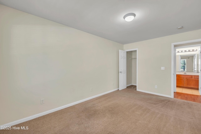 unfurnished bedroom featuring a closet, light colored carpet, and baseboards