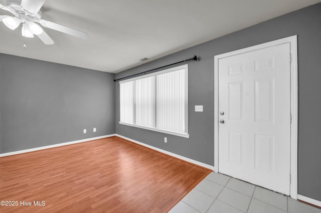 foyer entrance with light wood-type flooring, baseboards, and a ceiling fan