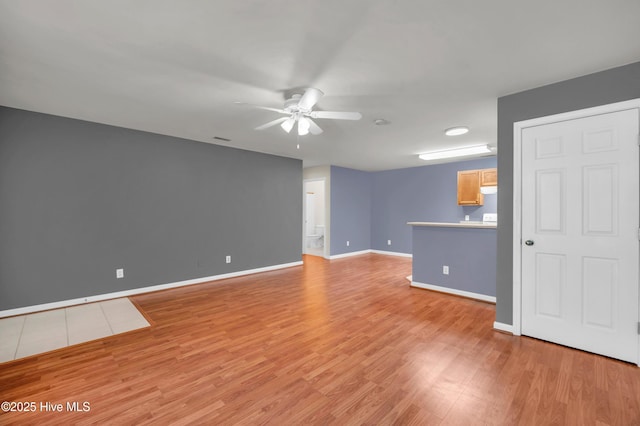 unfurnished living room with light wood-style flooring, baseboards, and a ceiling fan