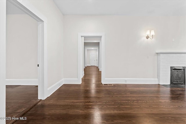 unfurnished living room with visible vents, baseboards, and wood finished floors