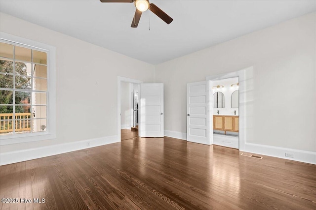 unfurnished bedroom featuring visible vents, ensuite bathroom, baseboards, and wood finished floors