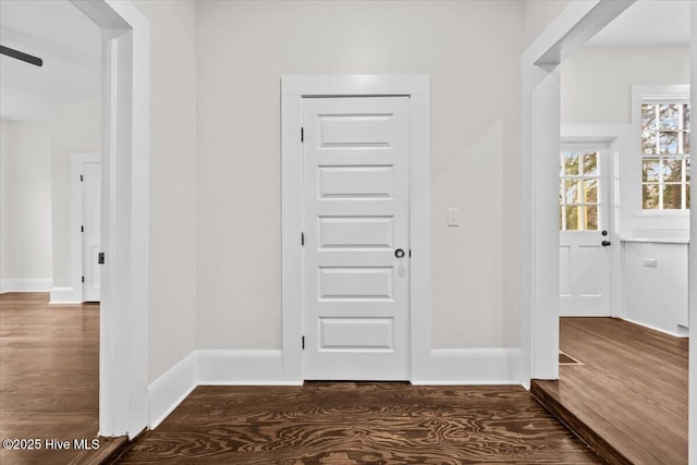 hallway with baseboards and wood finished floors