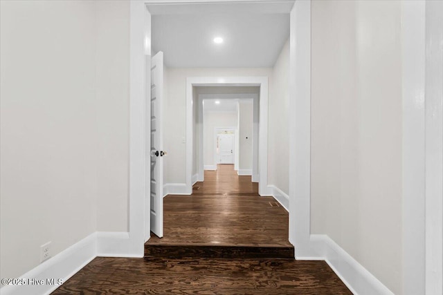 hall with dark wood-style floors and baseboards