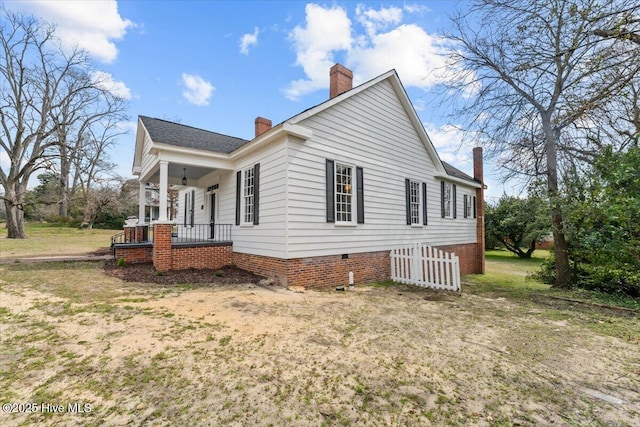 view of home's exterior featuring a porch and a chimney