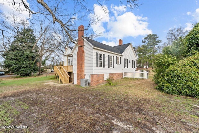 view of property exterior with stairway, central AC unit, a yard, a chimney, and a deck