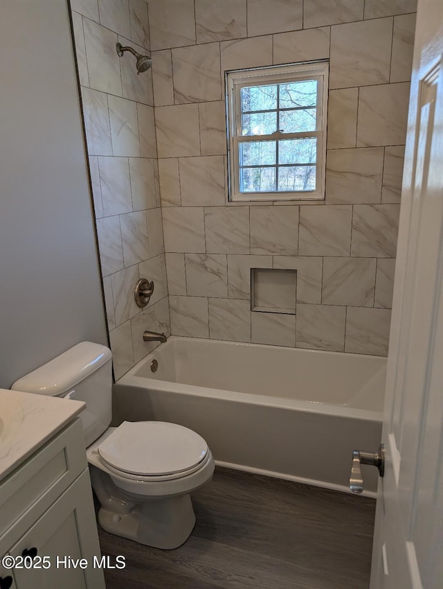 bathroom featuring vanity, wood finished floors, toilet, and tub / shower combination