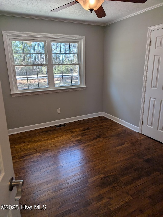 empty room with visible vents, baseboards, ceiling fan, and dark wood finished floors