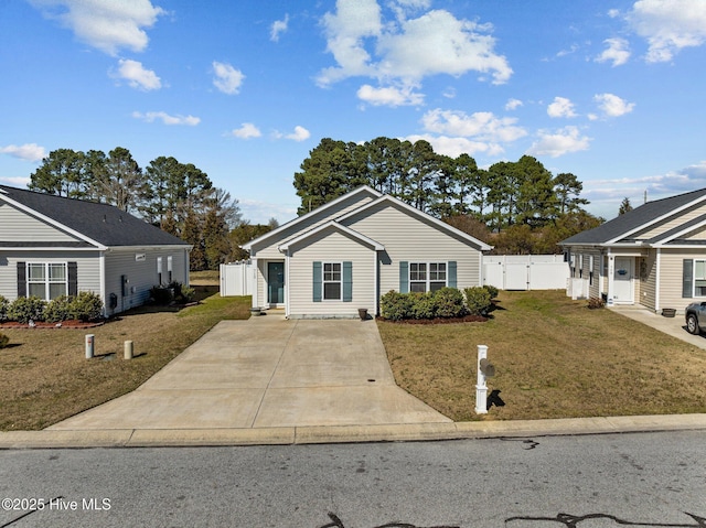 view of front facade with fence, concrete driveway, a front yard, and a gate