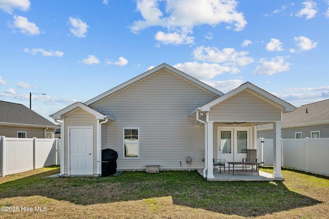 rear view of property with a fenced backyard, a lawn, a ceiling fan, and a patio