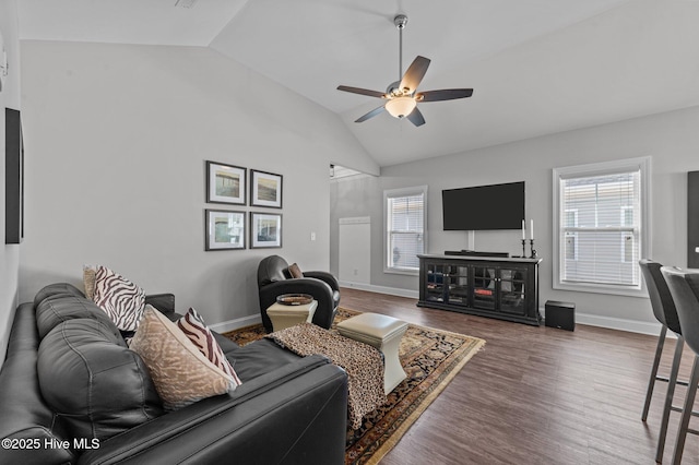 living room with ceiling fan, baseboards, lofted ceiling, and wood finished floors