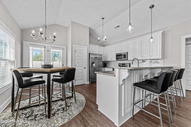 kitchen featuring white cabinetry, a peninsula, stainless steel appliances, and an inviting chandelier