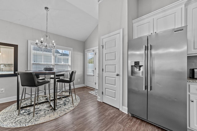 dining room with baseboards, a notable chandelier, dark wood-style floors, and vaulted ceiling