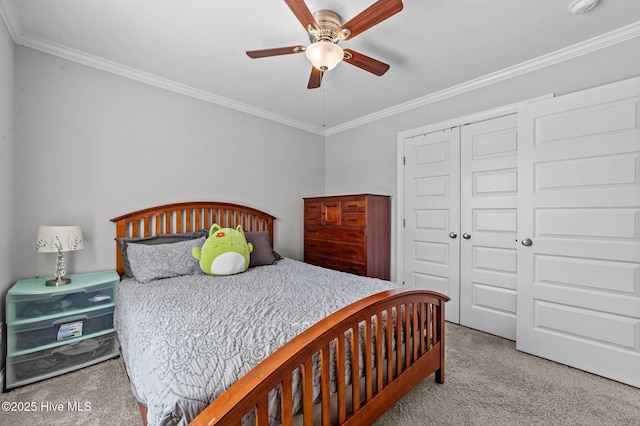 carpeted bedroom featuring ceiling fan, a closet, and ornamental molding