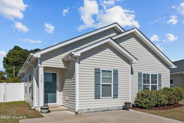 bungalow-style house with entry steps and fence