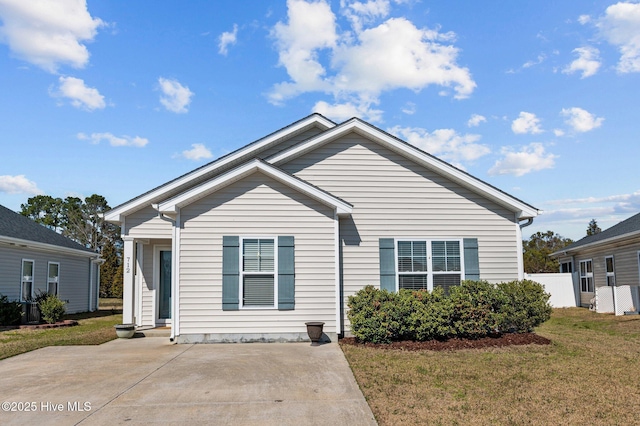 bungalow with a front lawn and fence