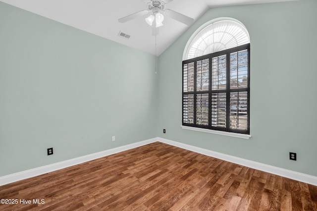 empty room featuring wood finished floors, a ceiling fan, visible vents, and baseboards