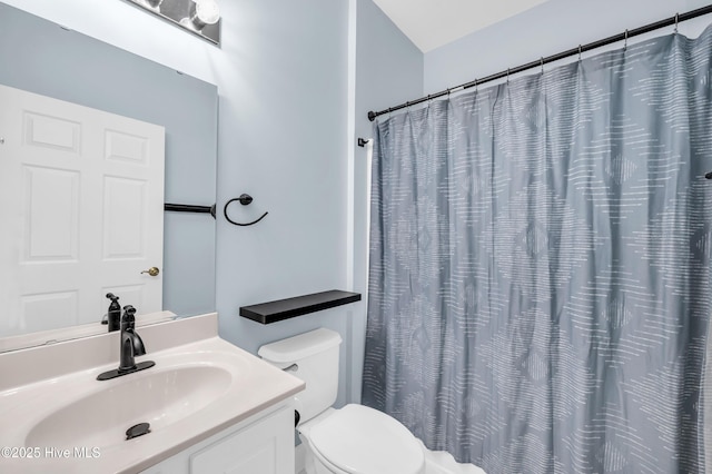 full bathroom featuring a shower with shower curtain, toilet, and vanity