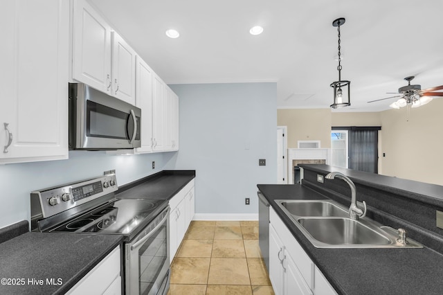 kitchen featuring a sink, dark countertops, white cabinetry, stainless steel appliances, and ceiling fan