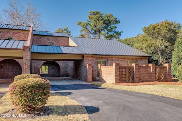 view of property featuring aphalt driveway and fence