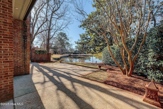 view of patio with a water view and driveway