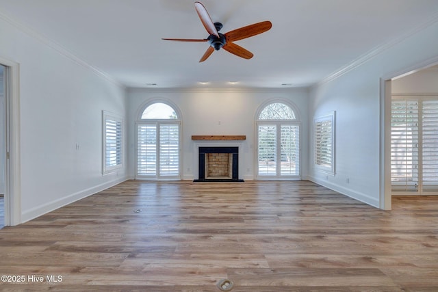 unfurnished living room with a fireplace with raised hearth, baseboards, ornamental molding, wood finished floors, and a ceiling fan