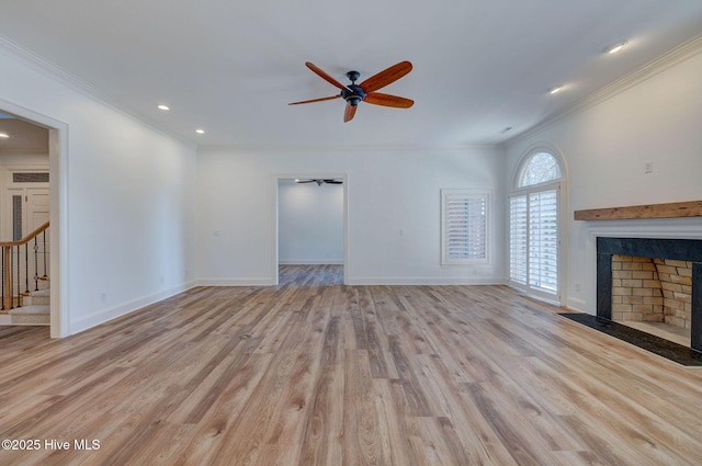 unfurnished living room featuring stairway, wood finished floors, ceiling fan, and a fireplace