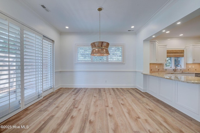 unfurnished dining area featuring visible vents, baseboards, light wood-type flooring, ornamental molding, and recessed lighting