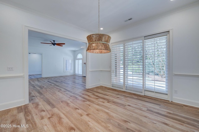 unfurnished dining area with visible vents, baseboards, wood finished floors, and ornamental molding