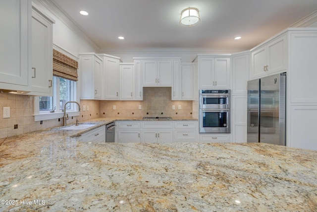 kitchen featuring a sink, light stone countertops, appliances with stainless steel finishes, and white cabinetry