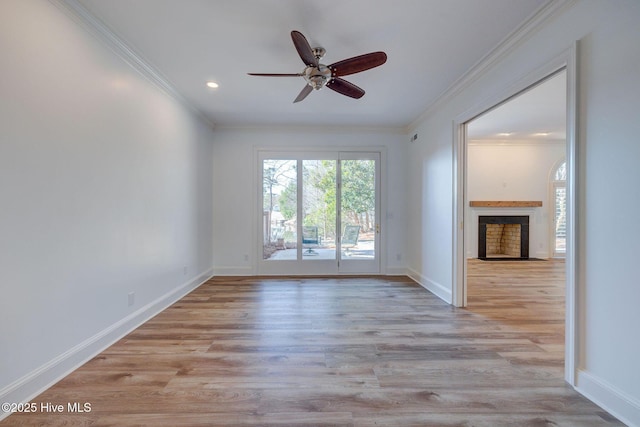 unfurnished living room with crown molding, baseboards, ceiling fan, a fireplace with flush hearth, and wood finished floors