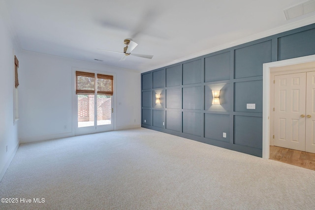 unfurnished bedroom featuring visible vents, light carpet, access to exterior, and a decorative wall