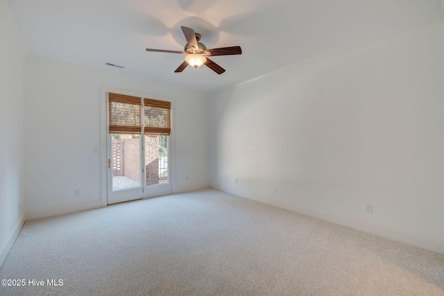 unfurnished room with visible vents, a ceiling fan, crown molding, baseboards, and light colored carpet