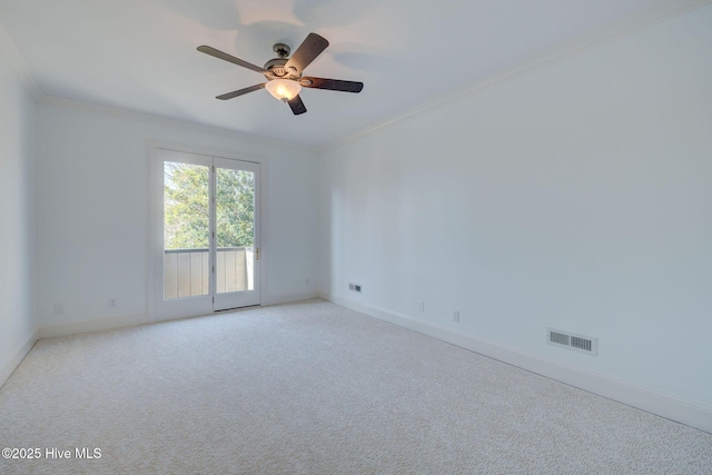 empty room with visible vents, carpet, crown molding, baseboards, and ceiling fan