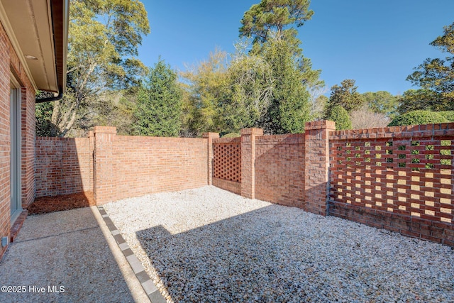 view of gate featuring a patio area and a fenced backyard