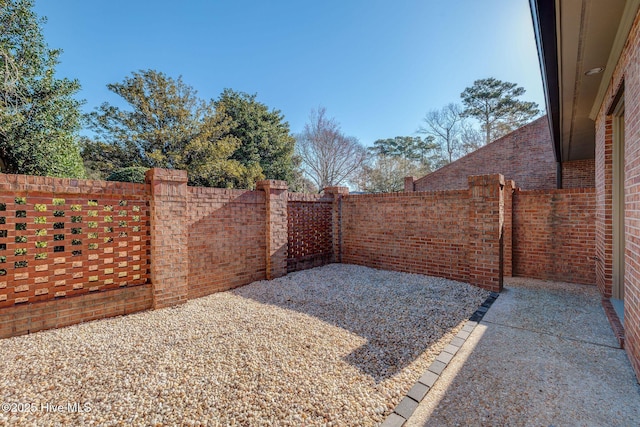 view of gate with a fenced backyard and a patio area