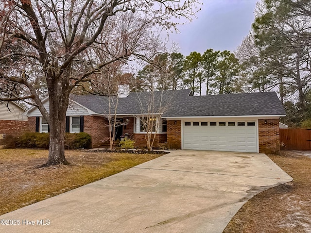 single story home with concrete driveway, brick siding, a garage, and a shingled roof