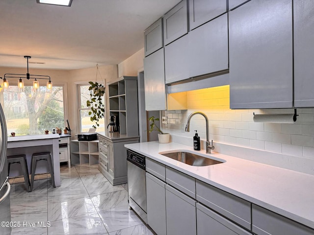 kitchen featuring marble finish floor, gray cabinetry, dishwasher, and a sink