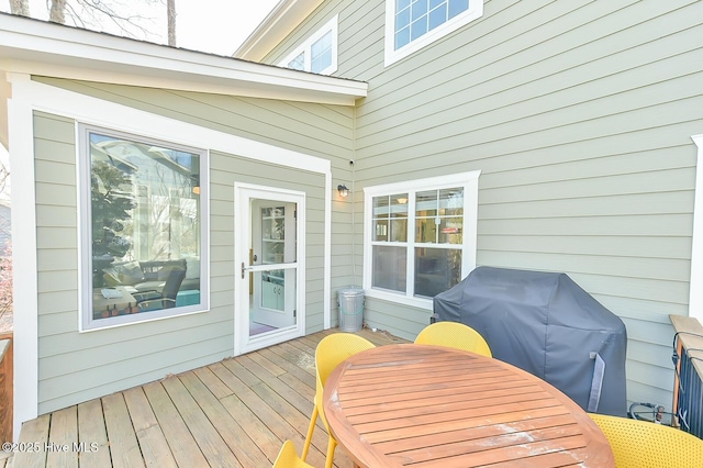 wooden terrace featuring outdoor dining area and a grill