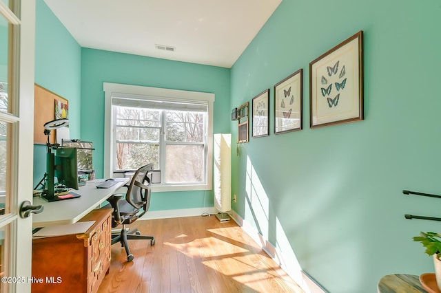 office area featuring visible vents, baseboards, and wood finished floors