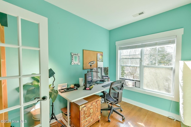 office space featuring visible vents, baseboards, and wood finished floors