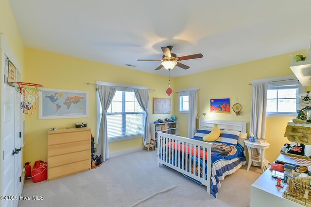 bedroom featuring multiple windows, ceiling fan, and carpet floors