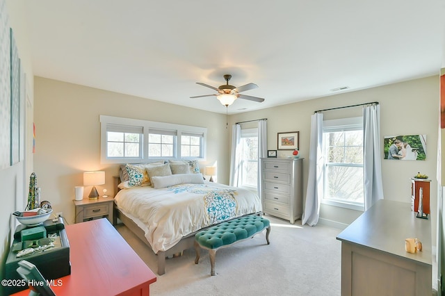 bedroom with baseboards, a ceiling fan, visible vents, and light carpet