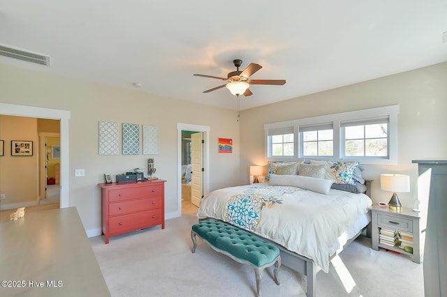 bedroom featuring visible vents, ceiling fan, baseboards, light carpet, and ensuite bath