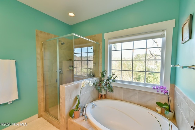 bathroom with recessed lighting, a stall shower, and a bath